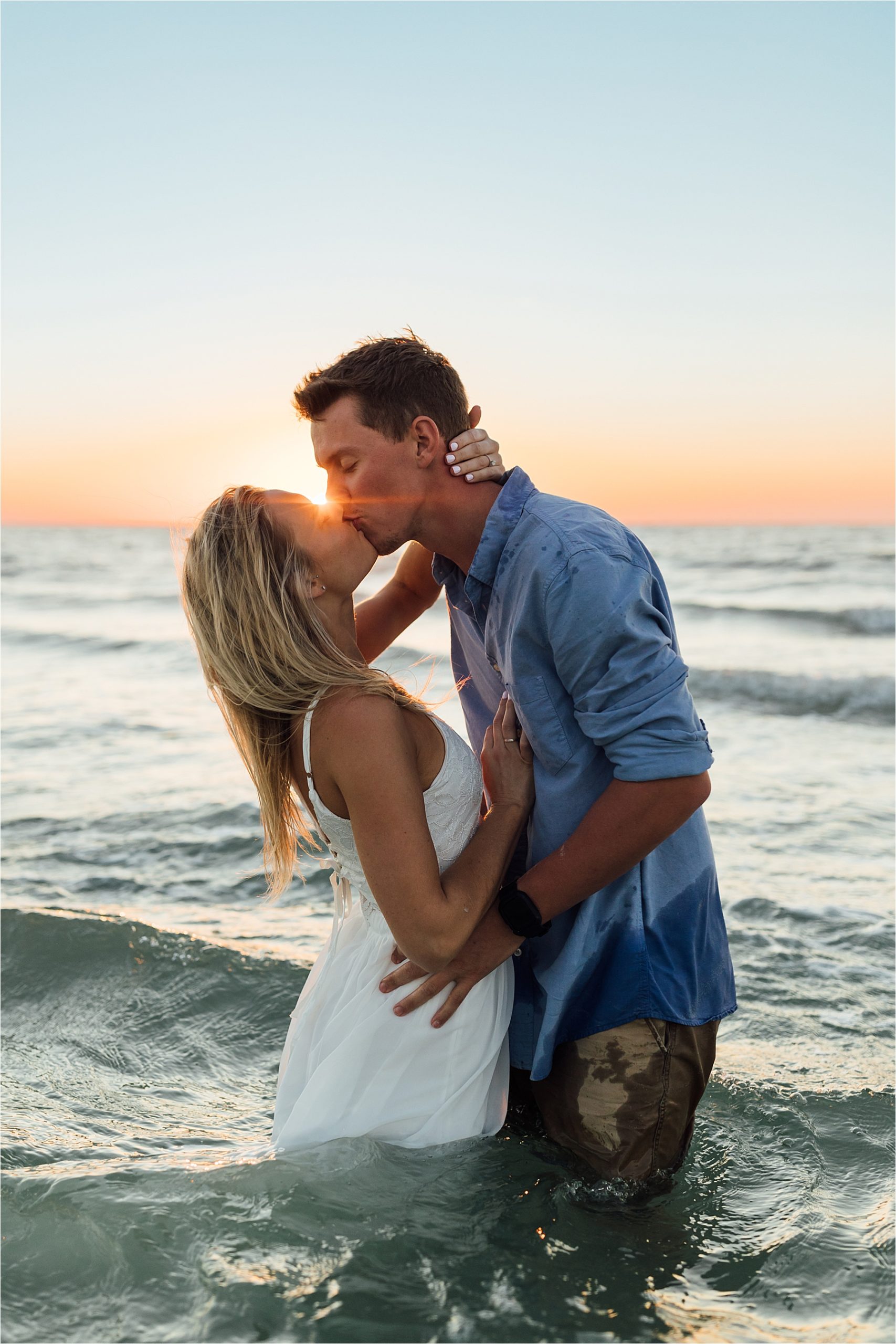 Sunset engagement photos, kissing in the water at Indian Shores beach
