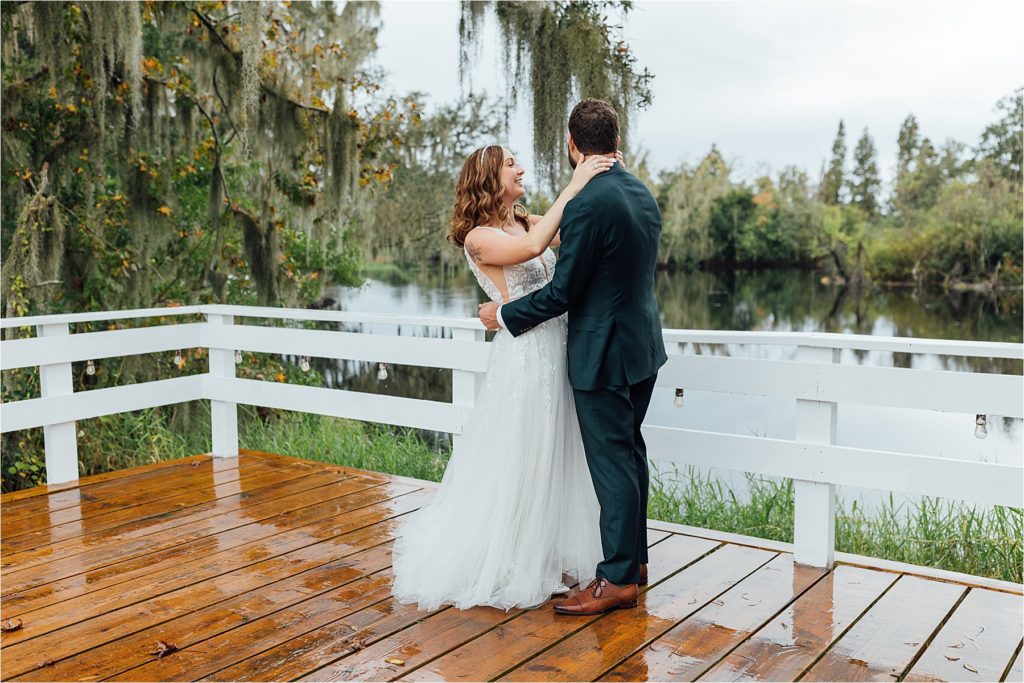 bride and groom kissing outdoors in the rain with Spanish moss trees