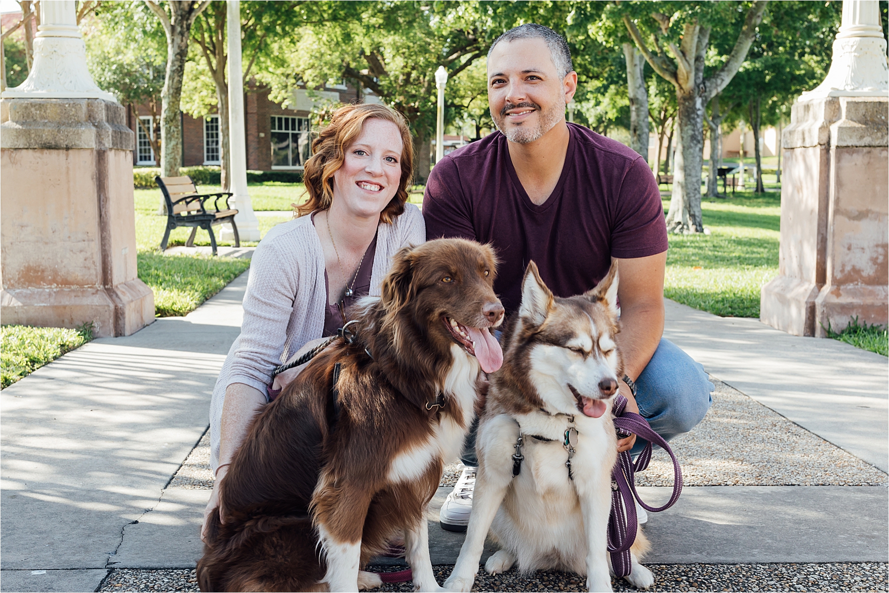 Couple during engagement photos with dogs smiling at camera