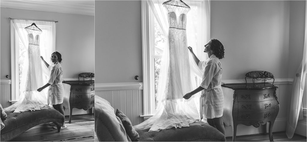 black and white of bride touching wedding dress