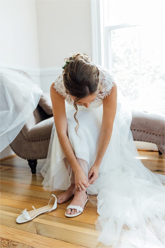 Close up of bride putting on wedding shoes